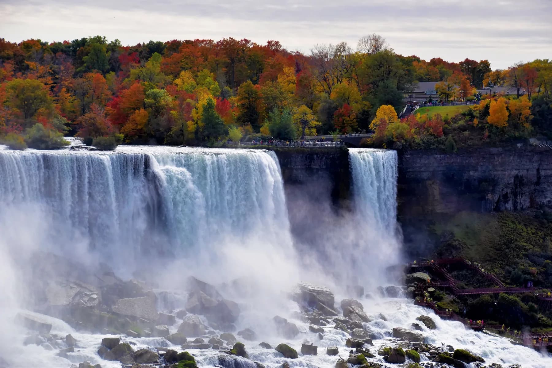 Niagara Falls below red, orange, and green autumn trees